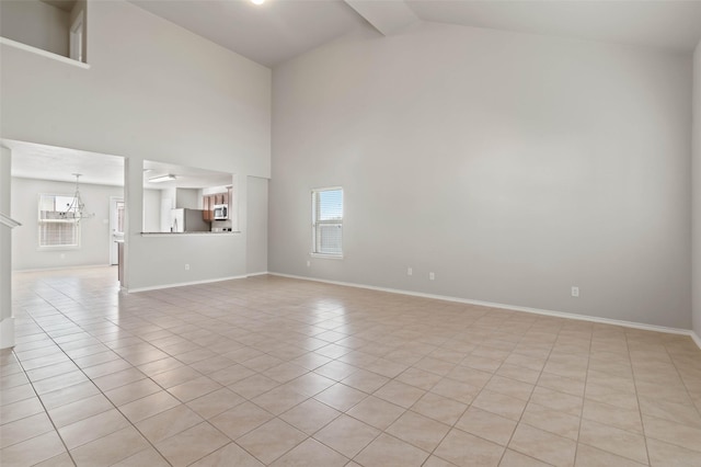 unfurnished living room featuring an inviting chandelier, high vaulted ceiling, and light tile patterned floors