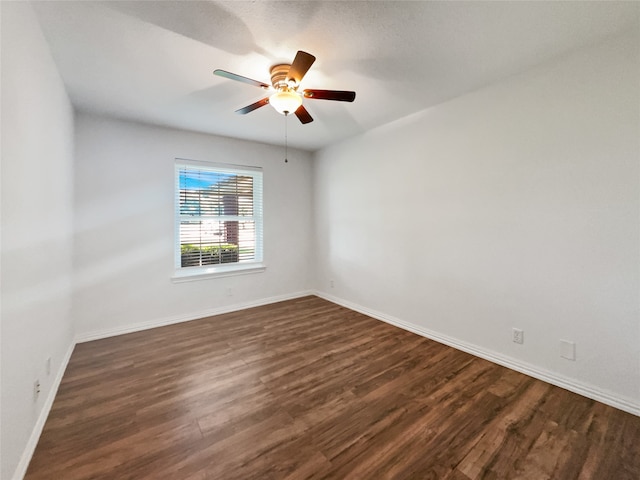 spare room featuring ceiling fan and dark wood-type flooring