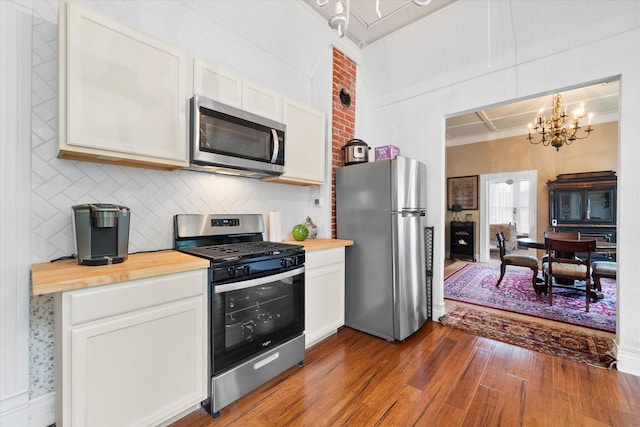 kitchen with white cabinetry, a chandelier, pendant lighting, and stainless steel appliances