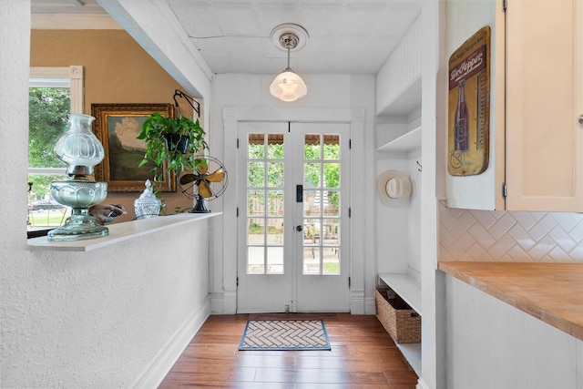 entryway with dark wood-type flooring, a wealth of natural light, and french doors