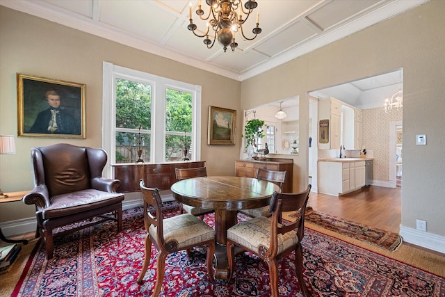 dining area with hardwood / wood-style floors, a notable chandelier, and sink