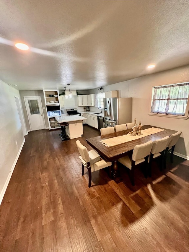 dining space with sink, plenty of natural light, and hardwood / wood-style flooring