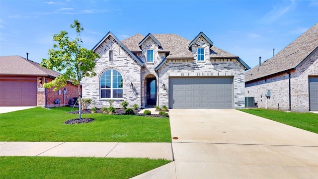 view of front of property with central air condition unit, a front lawn, and a garage