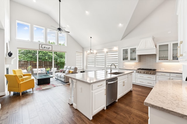 kitchen featuring sink, backsplash, a kitchen island with sink, white cabinets, and appliances with stainless steel finishes