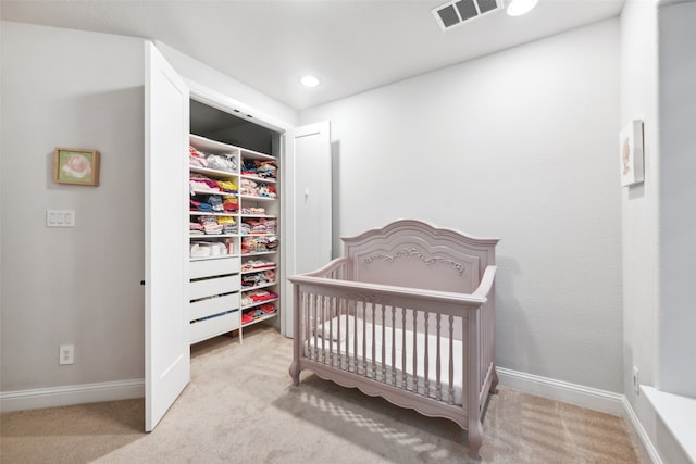 carpeted bedroom with a nursery area