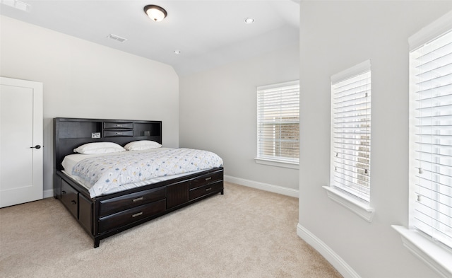 bedroom with light carpet and lofted ceiling