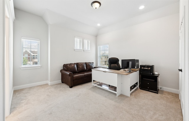 carpeted office space with a healthy amount of sunlight and vaulted ceiling