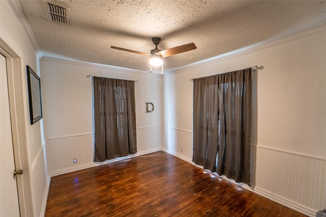 unfurnished room with ornamental molding, a textured ceiling, radiator, and dark wood-type flooring