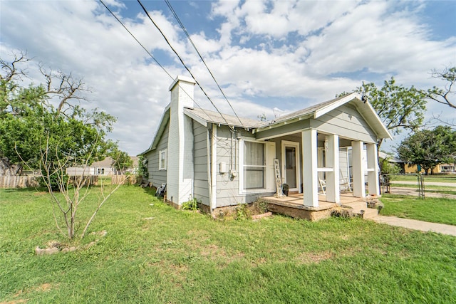 bungalow-style home with covered porch and a front lawn