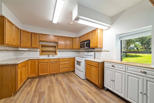 kitchen with decorative backsplash, light hardwood / wood-style floors, white electric stove, and sink