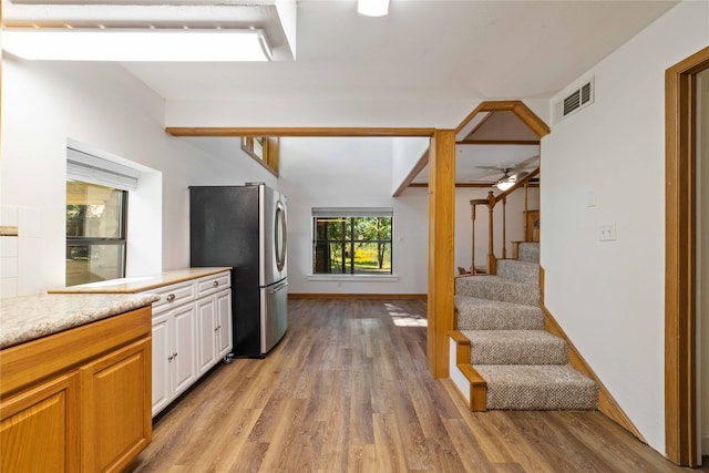 kitchen with stainless steel refrigerator, ceiling fan, and light hardwood / wood-style floors