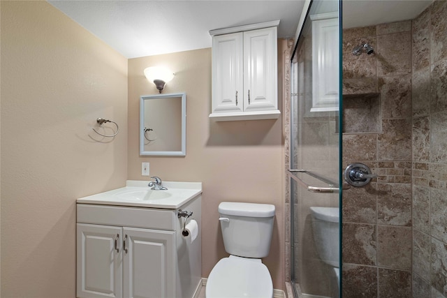 bathroom featuring vanity, toilet, and a shower with shower door