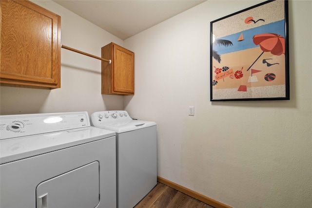 clothes washing area with cabinets, independent washer and dryer, and dark wood-type flooring