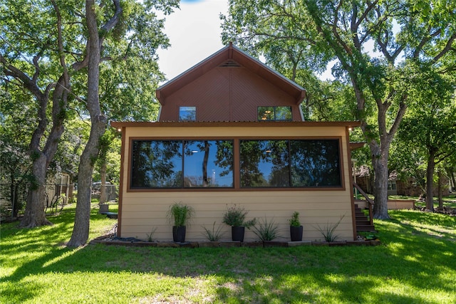 view of home's exterior featuring a sunroom and a yard