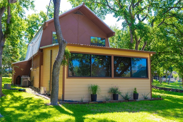 view of home's exterior with a yard and central AC