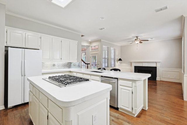 kitchen featuring ceiling fan, a center island, appliances with stainless steel finishes, and light hardwood / wood-style floors