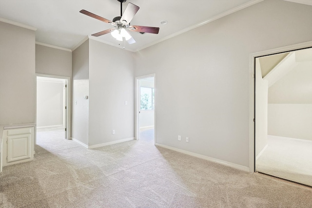 carpeted empty room with ceiling fan, crown molding, and lofted ceiling