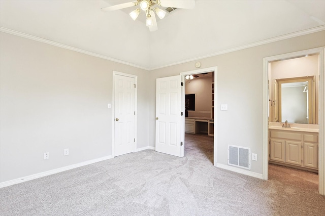 unfurnished bedroom with ceiling fan, ornamental molding, light colored carpet, and ensuite bathroom