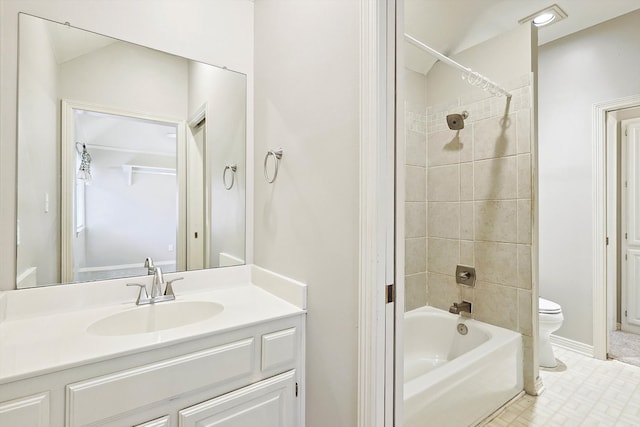 full bathroom featuring tile patterned flooring, vanity, tiled shower / bath combo, and toilet