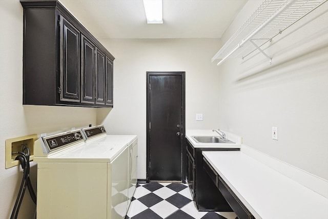 laundry area with sink, washing machine and dryer, cabinets, and light tile patterned floors