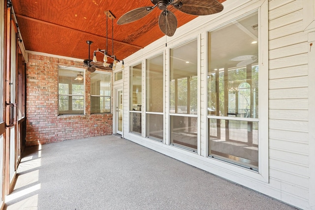 unfurnished sunroom featuring wood ceiling and ceiling fan