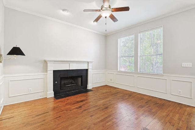 unfurnished living room featuring ceiling fan, a fireplace, crown molding, and wood-type flooring