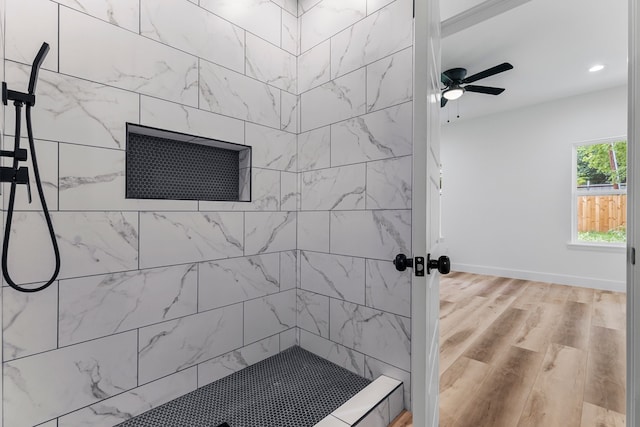 bathroom featuring hardwood / wood-style flooring, ceiling fan, and tiled shower