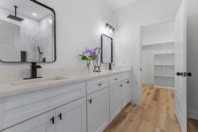 bathroom featuring a shower, hardwood / wood-style floors, and vanity