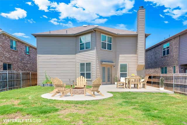 back of property with an outdoor fire pit, a yard, and a patio area