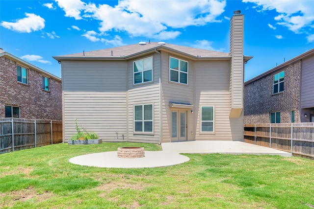 rear view of house featuring a lawn, a patio area, and a fire pit