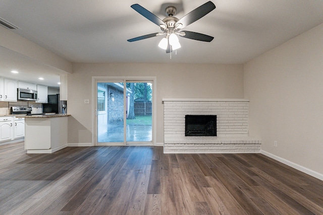 unfurnished living room with ceiling fan, a fireplace, and dark hardwood / wood-style floors