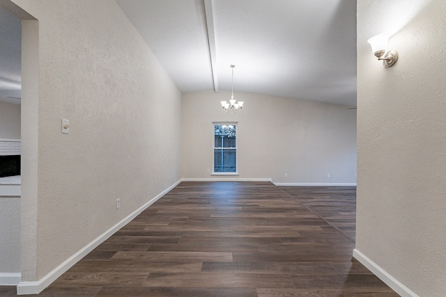 interior space featuring dark hardwood / wood-style flooring, a chandelier, vaulted ceiling, and a brick fireplace