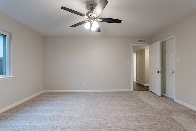 spare room with light colored carpet and ceiling fan