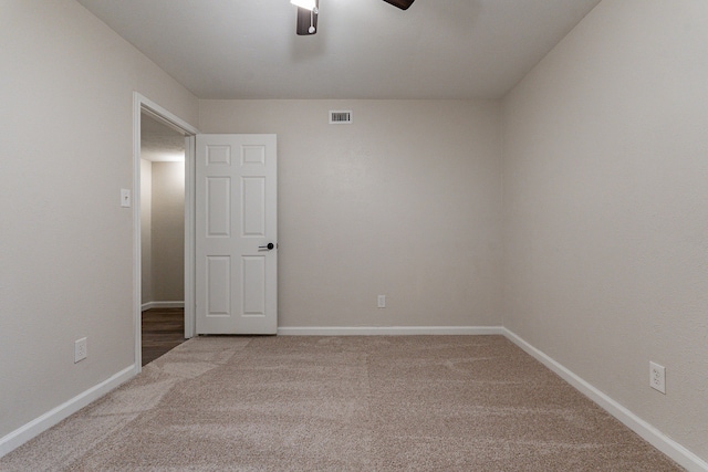 carpeted spare room featuring ceiling fan