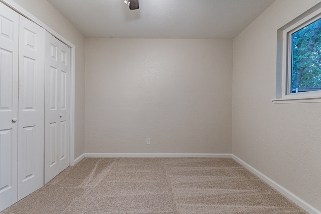 unfurnished bedroom featuring ceiling fan, carpet floors, and a closet