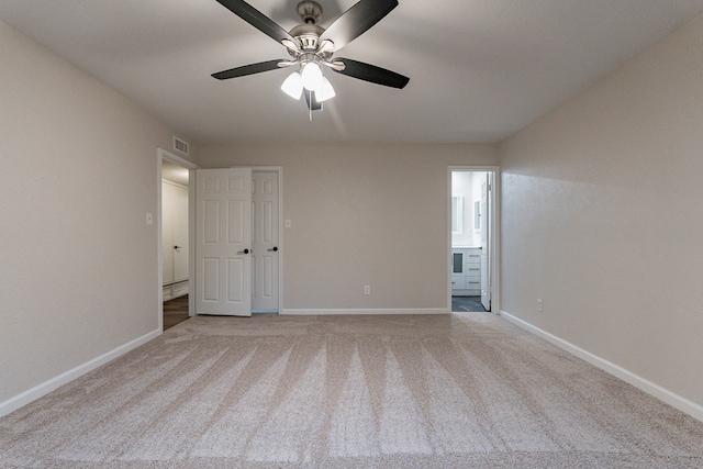 spare room featuring light carpet and ceiling fan