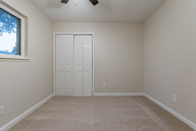 unfurnished bedroom featuring ceiling fan, a closet, and carpet floors