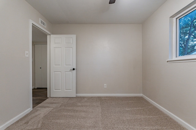 carpeted spare room with ceiling fan