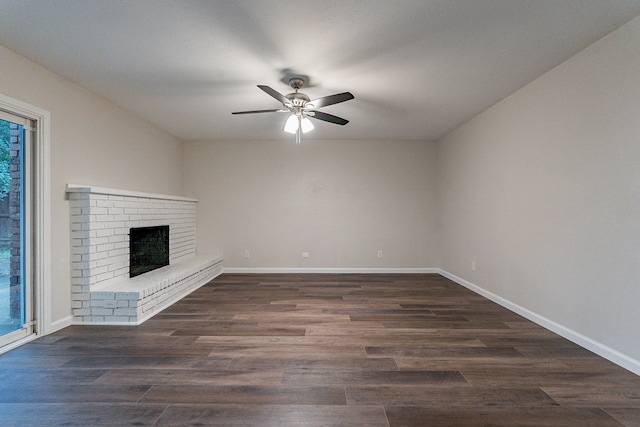 unfurnished living room featuring dark hardwood / wood-style floors, ceiling fan, and a fireplace