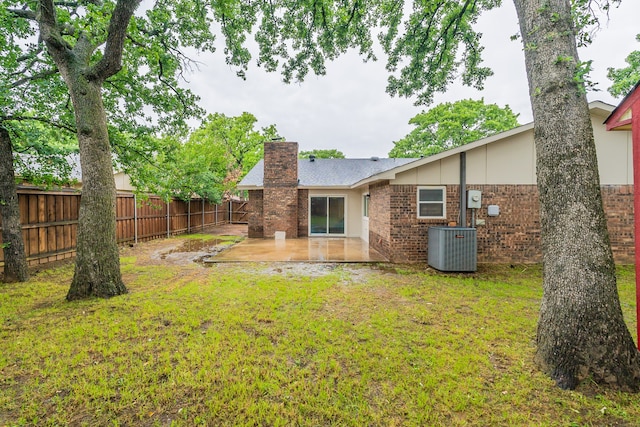 rear view of property featuring a yard, a patio, and central AC unit