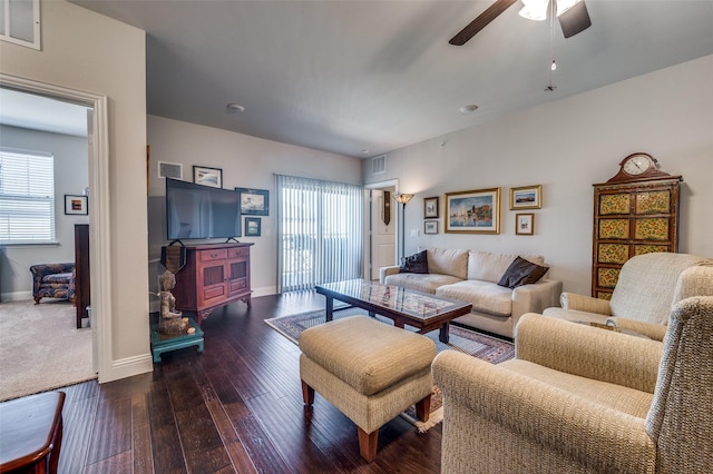 living room featuring ceiling fan and dark wood-type flooring