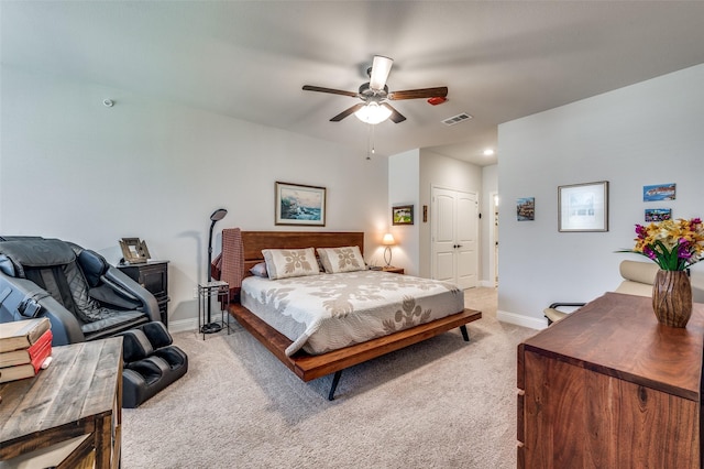 bedroom featuring ceiling fan, light colored carpet, and a closet