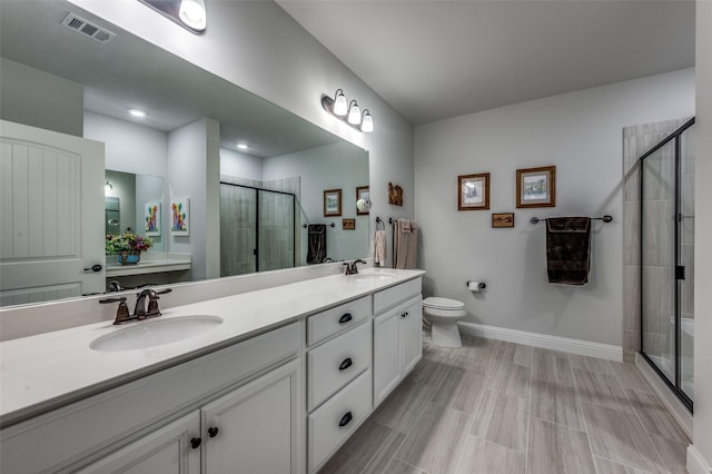 bathroom featuring toilet, vanity, and walk in shower