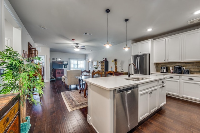 kitchen with appliances with stainless steel finishes, ceiling fan, dark wood-type flooring, pendant lighting, and white cabinets