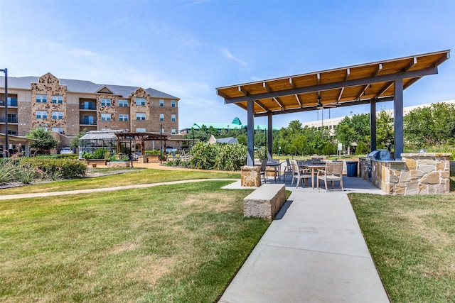 view of property's community with a yard, a patio, and exterior kitchen