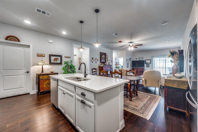 kitchen with a kitchen island with sink, dark wood-type flooring, hanging light fixtures, sink, and appliances with stainless steel finishes