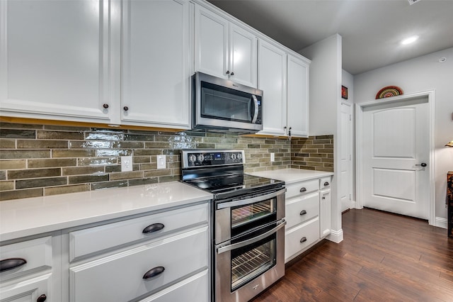 kitchen with white cabinets, decorative backsplash, dark wood-type flooring, and appliances with stainless steel finishes