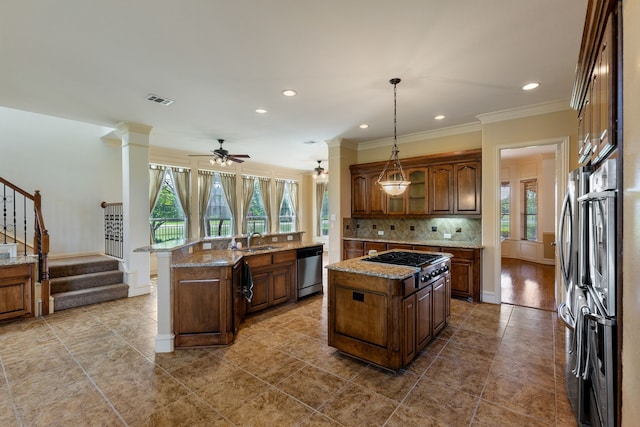 kitchen featuring a center island with sink, sink, hanging light fixtures, and appliances with stainless steel finishes