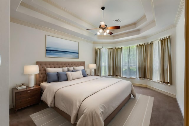 carpeted bedroom with a tray ceiling, ceiling fan, and ornamental molding