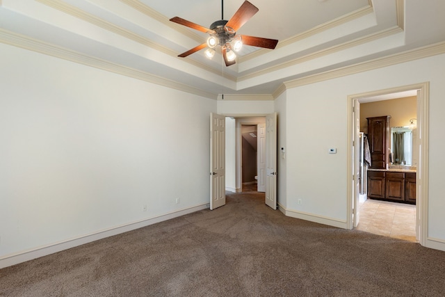 unfurnished bedroom with a raised ceiling, ceiling fan, crown molding, and light carpet